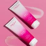 Két rózsaszín tubusos Curly Secret formázó zselé áttetsző zselés textúrával rózsaszín háttéren.