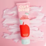 Rózsaszín tubusos Curl Bites Weightless Leave-In Conditioner balzsam, elkent krémes mintájú háttérrel.