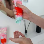 Fehér állagú kiöblítést nem igénylő kondicionáló adagolása a rózsaszín tubusból a tenyérbe.