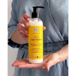 Kézben tartott sárga címkés Soivre Curly Method nem kiöblítendő kondicionáló fekete pumpás adagolófejjel.