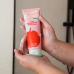 Habos kézben tartott rózsaszín Curl Bites Refreshing Weightless Shampoo tubus almás mintával.
