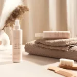 NAYEEL My First Soft Hair Mist permet flakonban, fésűvel, kefével és törölközőkkel bézs környezetben.