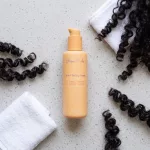 Rizos Curls 6-in-1 hajformázó krém asztalon, törölközővel