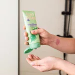 Curl Bites mélytisztító sampon adagolása zöld tubusból tenyérbe, a gél állagú sampon használat közben.