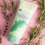 Curl Bites Rosemary mélytisztító sampon zöld tubusban, rozmaring illusztrációval, rozmaring növényekkel a fekvő palack mellett.