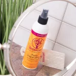 Jessicurl Awe Inspiraling Refresher Spray flakon és egy világos bontófésű tükörképe csempézett háttér előtt.